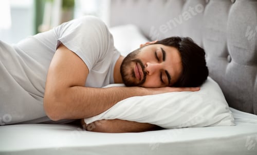 Preview: Comfortable sleep. Millennial arab man sleeping peacefully and see sweet dreams, lying in comfy bed