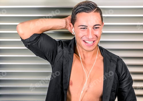 Preview: Portrait of a young man listening to music with headphones against a minimal background