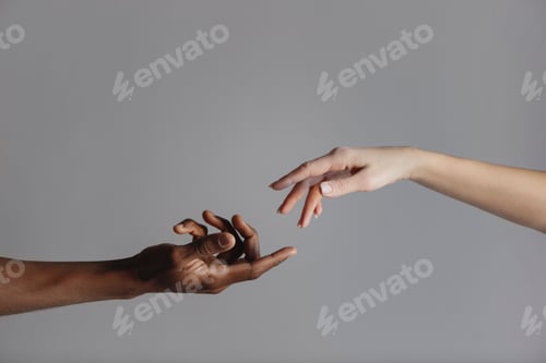 Preview: Hands of interracial couple on grey background.