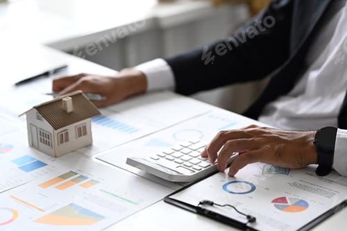 Preview: Mal investors hand using calculator for calculating loan of finance and planning for real estate.