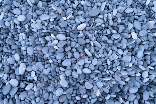 Preview: Gray pebbles as a background. Round stones on the beach.