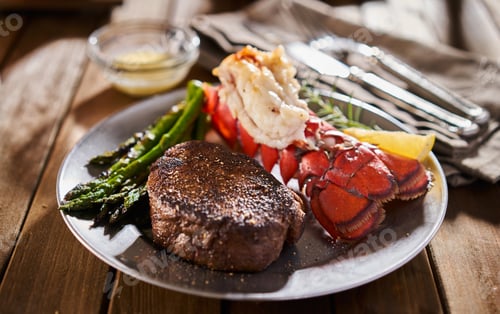 Preview: tasty surf & turf steak and lobster meal with asparagus on dinner plate