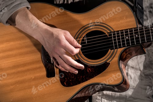 Preview: Guitarist, music. A young man plays an acoustic guitar on a black isolated background