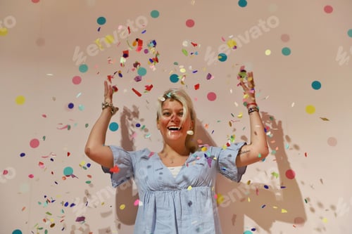 Preview: A young happy woman enjoying the confetti against a colourful background