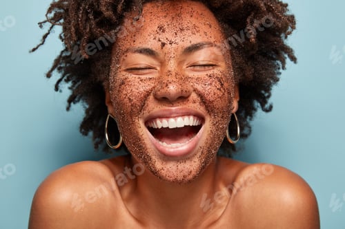 Preview: Overjoyed lady with peeling coffee scrub, laughs sincerely, has natural beauty, healthy dark skin, s