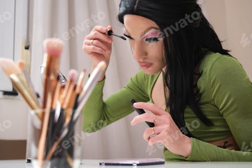 Preview: Drag queen person applying lash mascara.