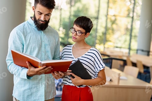 Preview: Happy group of students studying and working together in a college library