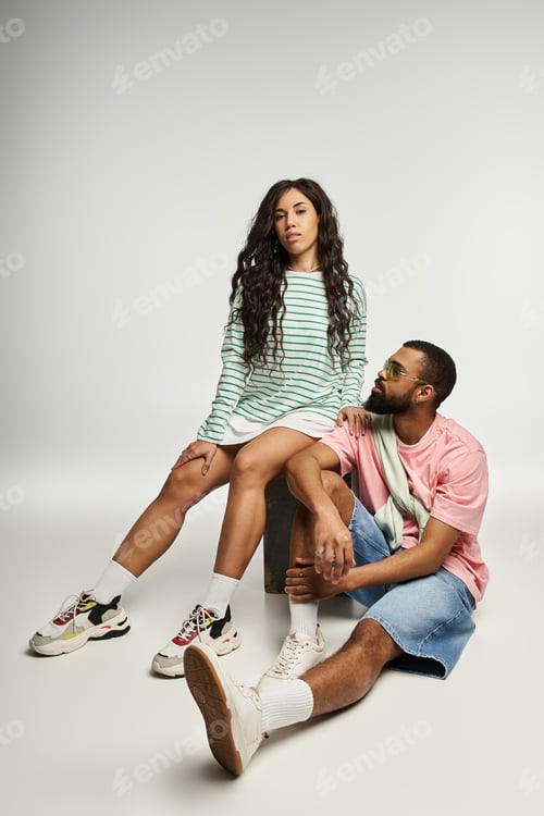 Preview: Stylish couple showcases modern fashion in playful and casual urban setting together