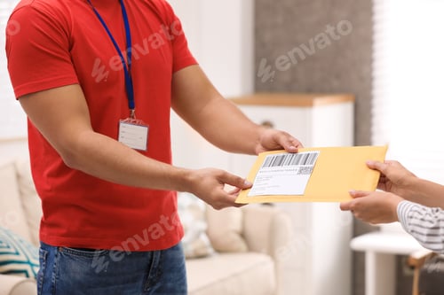 Preview: Woman receiving padded envelope from courier at home, closeup