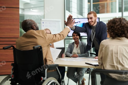 Preview: Two happy young intercultural businessmen giving each other high five