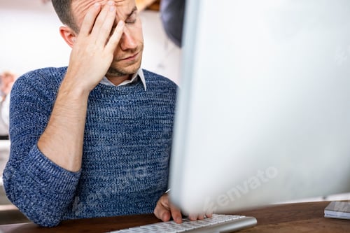 Preview: Stressed businessman working in an office
