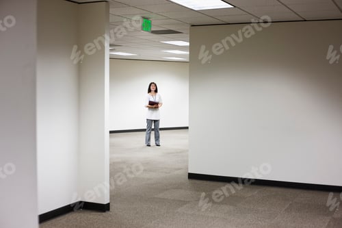 Preview: An asian businesswoman stanidng alone in her office space.