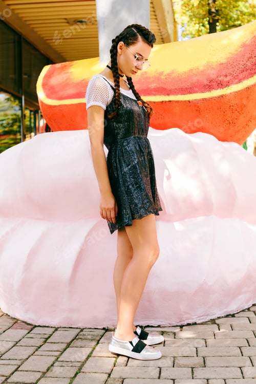 Preview: Girl Posing In A Park In Glasses Near A Large Marshmallow And Orange