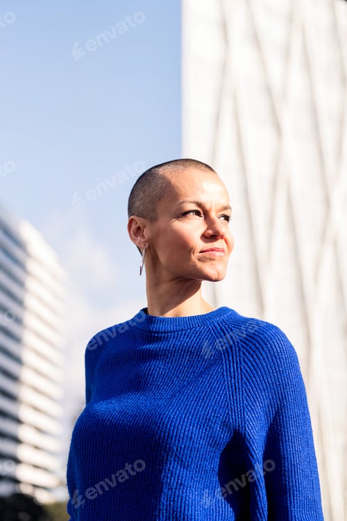 Preview: empowered woman with shaved head in cityscape
