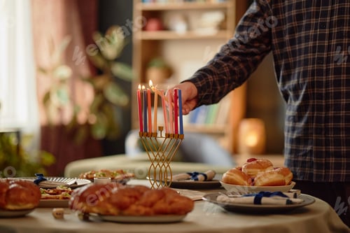 Preview: Man Lighting Menorah Candles during Hanukkah Celebration