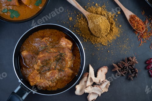 Preview: Massaman curry in a frying pan with spices on the cement floor