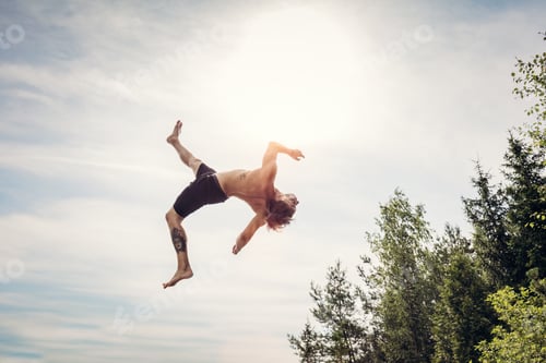 Preview: Young man doing a backflip in the air.