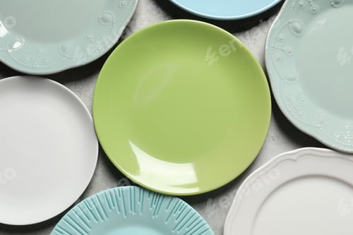 Preview: Beautiful ceramic plates on light grey table, flat lay