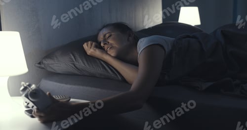Preview: Woman suffering from insomnia and checking the time