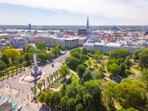 Preview: Aerial view of Riga with people running to the statue of liberty Milda during summer Marathon