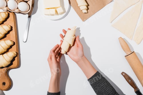 Preview: Cropped View of Woman Making Croissant on White Background