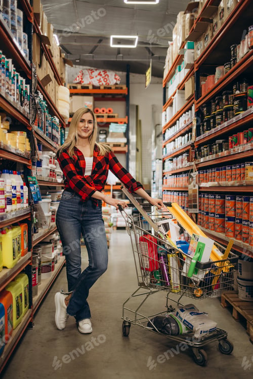 Preview: happy young woman shopping at hardware store