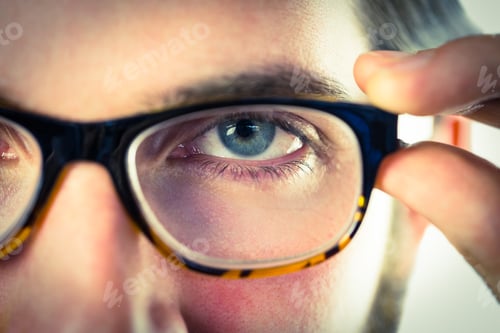 Preview: Handsome hipster touching his glasses on vignette background
