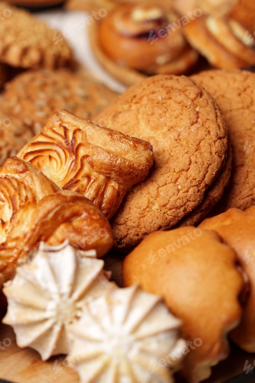 Preview: Variety of freshly baked cookies arranged on a wooden platter showcasing different textures and