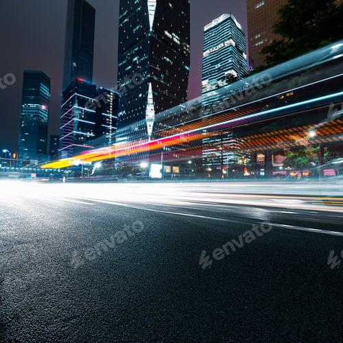 Cityscape at Night with Light Streaks on Road