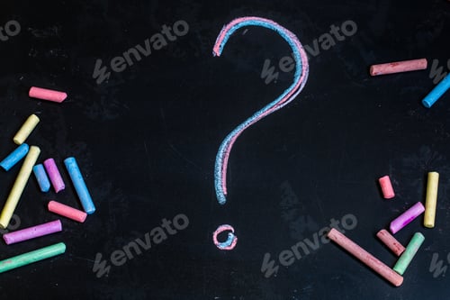 Preview: colored chalks, black blackboard with pictures question mark