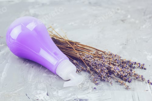 Preview: dry lavender flowers bunch and a cosmetic product with color and scent of lavender in the bottle