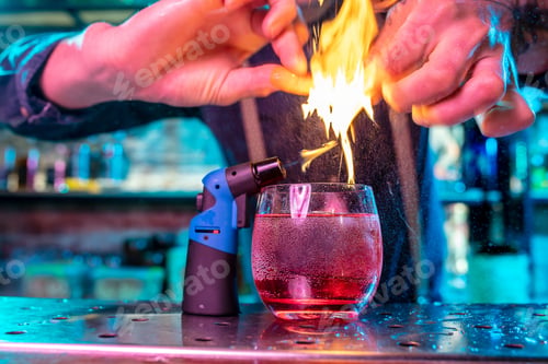 Preview: Close up of alcoholic cocktail, beverage, drink in multicolored neon light with fire flames setting