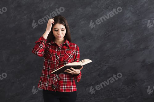 Preview: Thoughtful Girl Student In Checkered Shirt Reading Book, Copy Space