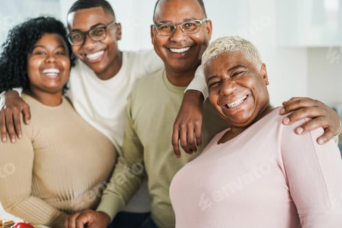 Preview: Happy black family having fun inside kitchen at home - Focus on mother face