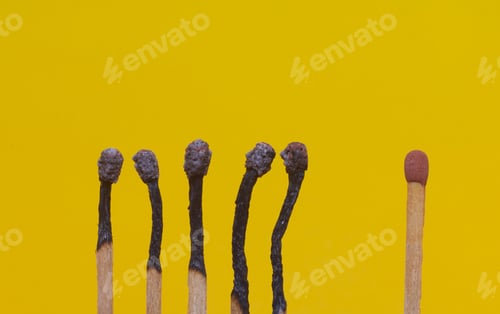 Preview: Shot of several burnt matches close to each other and one unlit located apart