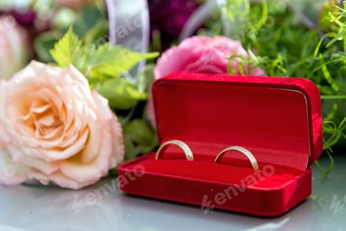 Vista previa: Adorno de flores y anillo en el capó gris del coche de bodas.