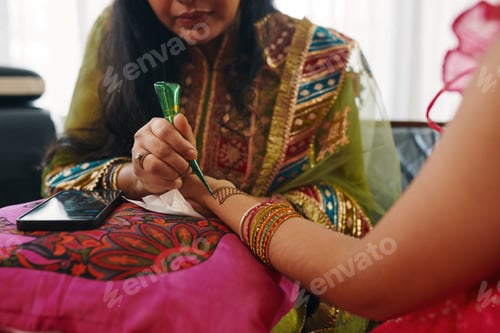 Preview: Mom Drawing Henna Patterns On Hand Of Her Daughter