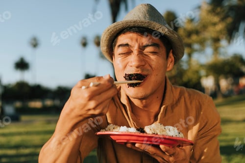 Preview: Man eating sushi in the park