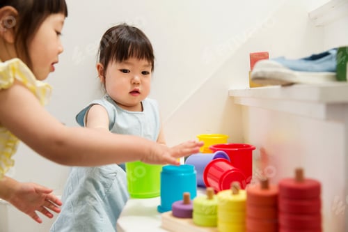 Preview: Two young sisters playing with toys on staircase