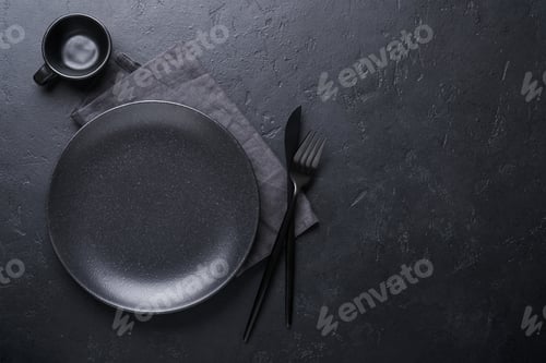 Preview: Black spoon, fork, knife and clean empty black plate. Set of stylish black and gold cutlery on black
