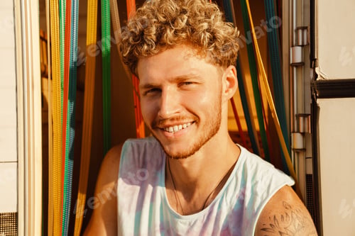 Preview: Ginger young man smiling and looking at camera while standing by trailer