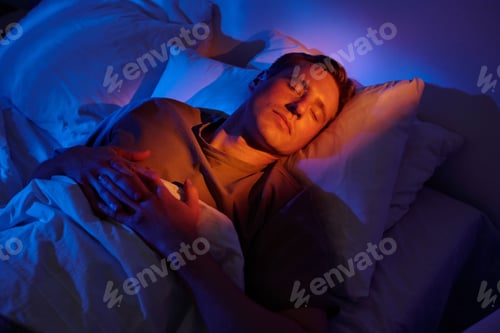 Preview: Man Sleeping in Bed under Soft Blue Lighting