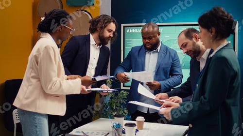 Preview: Diverse business affiliates studying market trends by reviewing finances