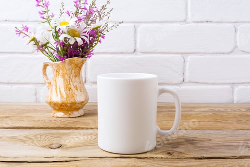 Preview: White coffee mug mockup with chamomile and purple flowers in gol