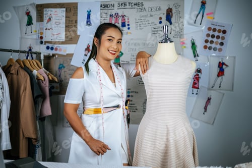 Preview: Young Asian fashion designer working with mannequin at workshop