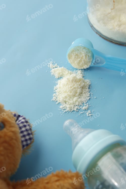 Preview: Close up of baby milk powder and spoon on tile background.