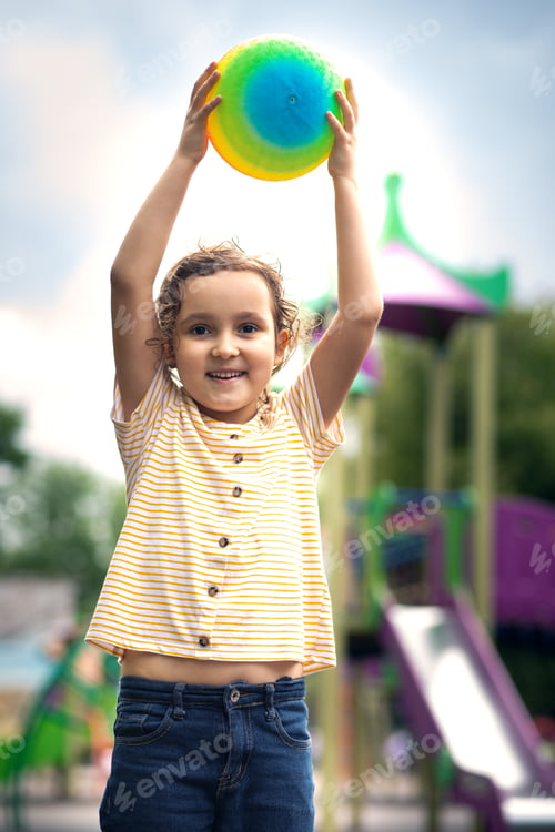 Preview: Portrait of happy kid girl child in park with colorful rainbow ball