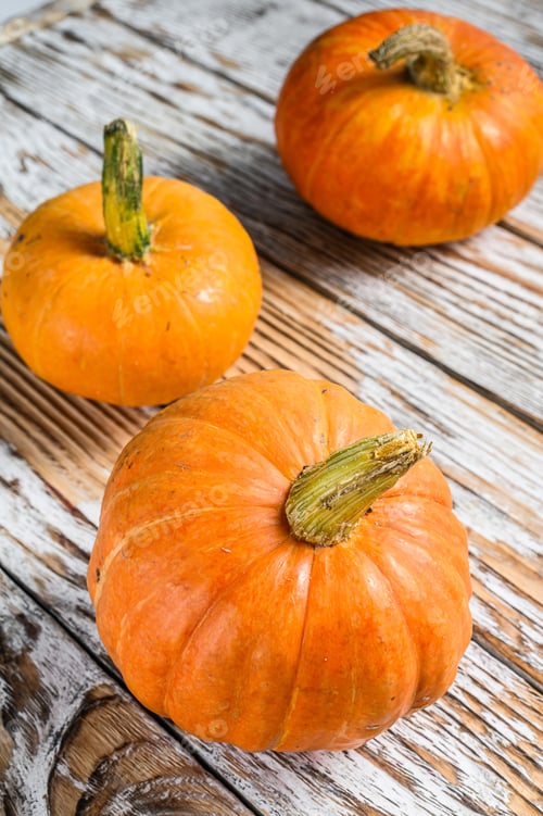 Preview: Whole raw orange pumpkins. White wooden background. Top view