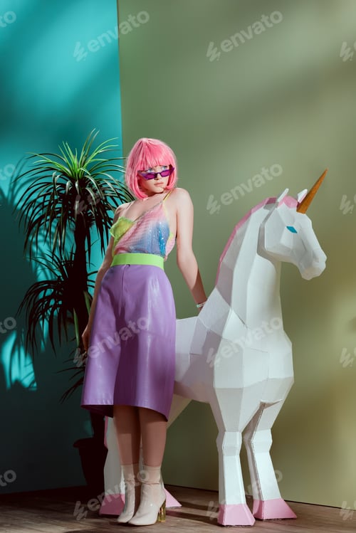 Preview: fashionable beautiful girl in pink wig leaning at unicorn