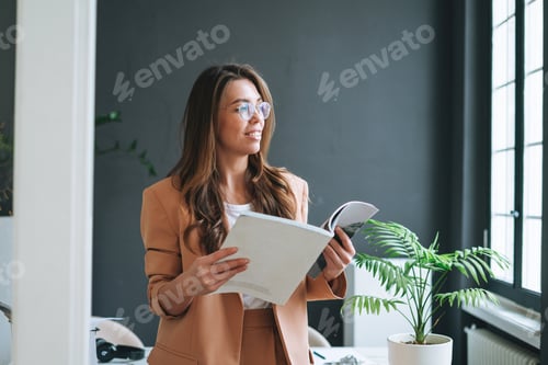 Preview: Portrait of Stylish business woman with magazine in bright modern office